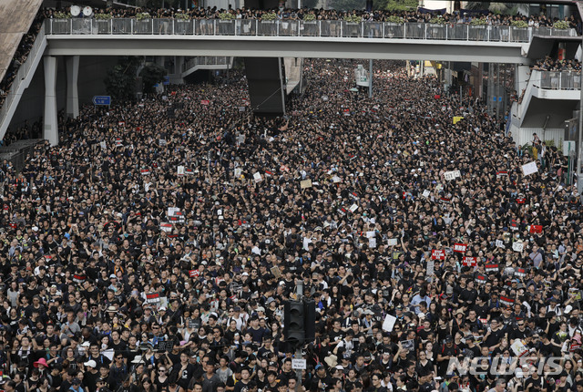 Protesters march through the streets against an extradition bill on Sunday, June 16, 2019, in Hong Kong. Hong Kong residents Sunday continued their massive protest over an unpopular extradition bill that has highlighted the territory's apprehension about relations with mainland China, a week after the crisis brought as many as 1 million into the streets. (AP Photo/Vincent Yu)