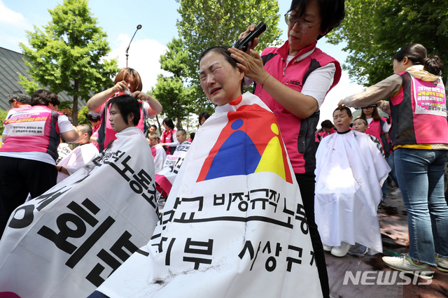 【서울=뉴시스】전신 기자 = 17일 서울 종로구 청와대 사랑채 옆 도로에서 학교비정규직 여성노동자들이 총파업 승리 삭발 투쟁 결의대회를 하고 있다. 2019.06.17. photo1006@newsis.com