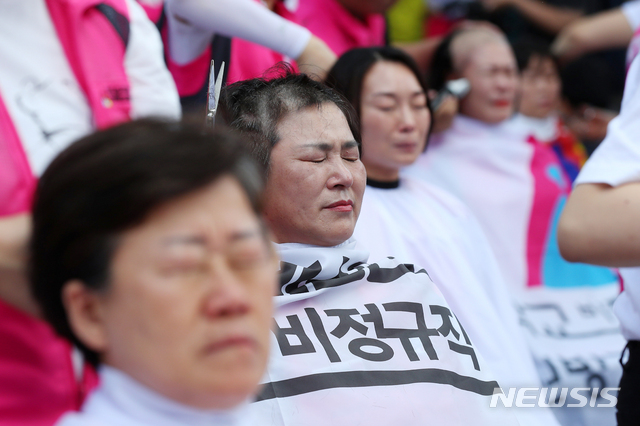 【서울=뉴시스】전신 기자 = 17일 서울 종로구 청와대 사랑채 옆 도로에서 학교비정규직 여성노동자들이 총파업 승리 삭발 투쟁 결의대회를 하고 있다. 2019.06.17. photo1006@newsis.com