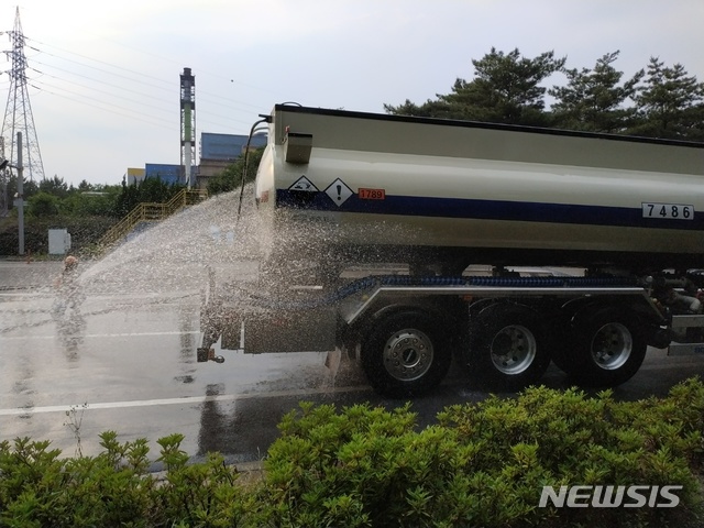 【포항=뉴시스】강진구 기자 = 18일 오후 5시22분께 경북 포항시 남구 괴동동 A제철소 2문앞 도로에서 유해화학물질인 염산 3000ℓ를 싣고 가던 21t 탱크로리에서 염산이 누출됐다.사진은 탱크로리에 물을 뿌리고 있는 소방관들.2019.06.18.(사진=독자 제공)&nbsp; photo@newsis.com