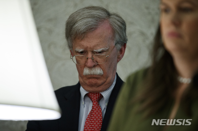 【워싱턴=AP/뉴시스】도널드 트럼프 미국 대통령이 20일(현지시간) 워싱턴 백악관 집무실에서 쥐스탱 트뤼도 캐나다 총리와 만나는 동안 존 볼턴 국가안보보좌관이 뒤에 서서 심각한 표정을 짓고 있다. 2019.06.21 