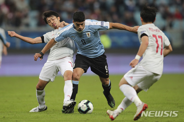 【포르투 알레그레(브라질)=AP/뉴시스】 시바사키 가쿠(왼쪽)와 몸싸움을 펼치는 루이스 수아레스