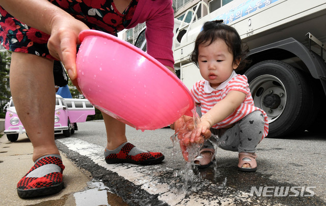 【서울=뉴시스】추상철 기자 = 21일 오후 붉은 수돗물이 나온 서울 영등포구 문래동 아파트단지에서 어린아이가 급수차 물에 손을 씻고 있다. 2019.06.21. scchoo@newsis.com