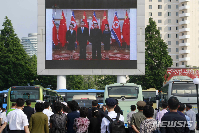 【평양=AP/뉴시스】21일 평양의 평양역에서 북한 주민들이 대형화면으로 중계되는 시진핑 중국 국가주석과 김정은 북한 국무위원장의 회담 장면을 지켜보고 있다. 2019.06.21. 