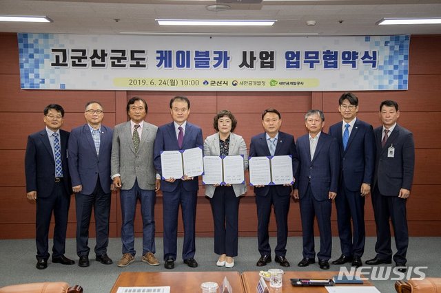 24일 전북 군산시청에서 열린 '고군산군도 케이블카 사업 업무협약식'에서 강임준 군산시장, 김현숙 새만금개발청장, 강팔문 새만금개발공사 사장이 협약서에 서명한 뒤 관계자들과 함께 기념촬영을 하고 있다. (사진=군산시 제공)