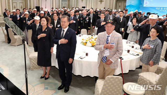 【서울=뉴시스】전신 기자 = 문재인 대통령이 24일 청와대 영빈관에서 열린 국군 및 유엔군 참전유공자 초청 오찬에서 국기에 경례하고 있다. 2019.06.24.&nbsp; photo1006@newsis.com