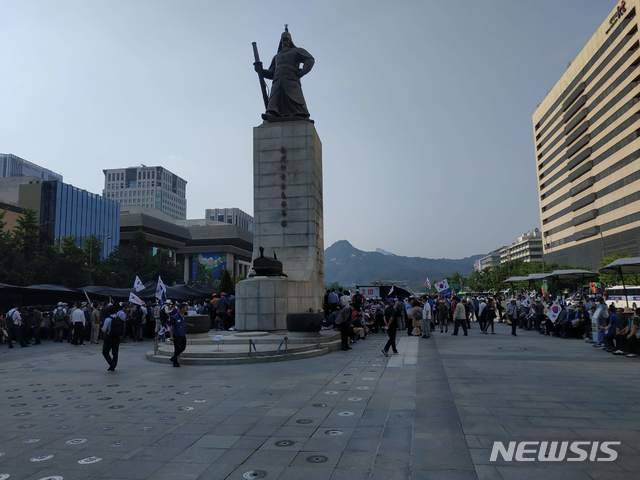 【서울=뉴시스】최현호 기자 = 지난 25일 광화문 광장 보행로 양쪽을 모두 막고 있는 우리공화당 지지자들. 이순신 동상 뒤쪽에서 조원진 우리공화당 대표 등이 발언을 진행하고 있다. 2019.6.25 photo@newsis.com