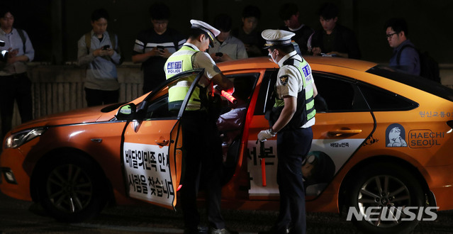 【서울=뉴시스】홍효식 기자 = 음주운전 단속 기준이 강화된 25일 오전 서울 마포구 합정동 양화대교 북단 일대에서 경찰들이 음주단속을 실시하고 있는 가운데 한 택시기사가 적발되고 있다. 한편, 면허 정지 기준은 혈중알코올농도 기존 0.05%에서 0.03%로, 취소 기준은 0.1%에서 0.08%로 강화되며, 처벌 기준도 현행 최고 징역 3년 또는 벌금 1천만 원에서 최고 징역 5년 또는 2천만 원으로 높아졌다. 2019.06.25. yesphoto@newsis.com