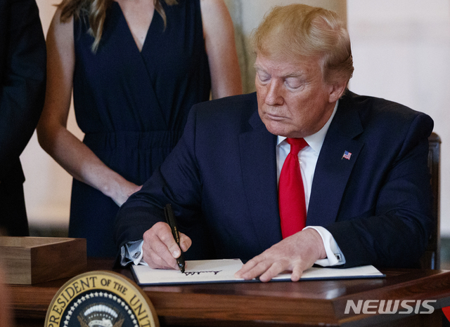 【워싱턴=AP/뉴시스】도널드 트럼프 미국 대통령이 24일(현지시간) 백악관 집무실에서 병원이 일반 검사와 시술의 실제 비용을 사전 공개하라는 행정명령에 서명하고 있다. 트럼프 대통령은 앞서 대(對)이란 추가 제재 행정명령에도 서명하면서 "이란에 경이로운 미래가 있고 많은 사람이 그 위대한 미래를 향한 일에 착수하길 바란다"라고 말했다. 2019.06.25.