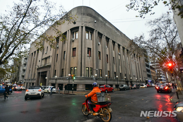 【몬테비데오(우루과이)=AP/뉴시스】24일(현지시간) 우루과이 수도 몬테비데오에 위치한 우루과이 경찰청 구치소 '카르텔 센트럴' 앞을 사람들이 지나고 있다. 2019.06.25