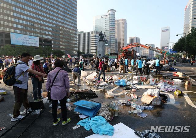 【서울=뉴시스】이영환 기자 = 서울시가 25일 오전 광화문 광장에 설치된 대한애국당 천막을 철거하자 당원들이 자리를 지키고 있다.서울시는 이날 오전 5시20분께부터 광화문 광장에 설치된 대한애국당 천막 등에 대한 행정대집행을 실시했다. 2019.06.25.  20hwan@newsis.com