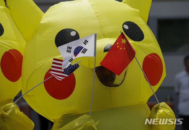 [마닐라=AP/뉴시스]미국 정부가 일본 주재 미국대사관에 중국 감시를 목적으로 공무원을 파견할 전망이다. 사진은 피카츄 복장을 한 환경운동가가 2019년 6월25일(현지시각) 필리핀 수도 마닐라 주재 일본대사관 앞에서 성조기, 태극기, 오성홍기를 들고 시위하는 모습. 2024.05.18.