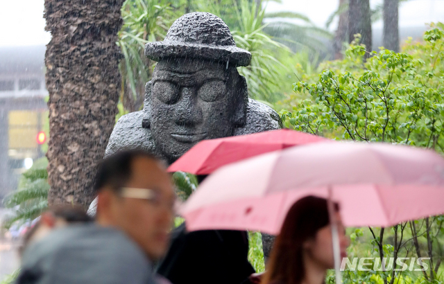 【제주=뉴시스】우장호 기자 = 올해 첫 장맛비가 내린 26일 오전 제주국제공항에 우산을 쓴 관광객들이 걸어가고 있다. 2019.06.26.&nbsp; woo1223@newsis.com