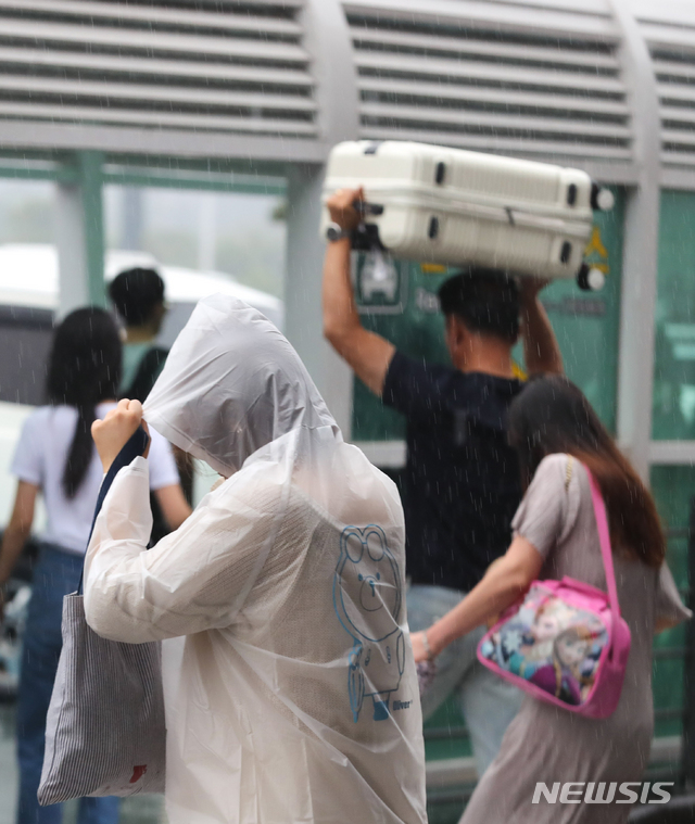 【제주=뉴시스】우장호 기자 = 올해 첫 장맛비가 내린 지난 26일 오전 제주국제공항 이용객들이 비를 피하며 발걸음을 재촉하고 있다. 2019.06.26. woo1223@newsis.com