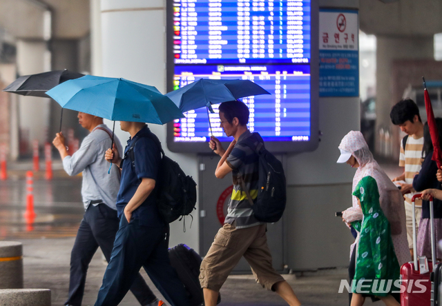 【제주=뉴시스】우장호 기자 = 올해 첫 장맛비가 내린 26일 오전 제주국제공항에 우산을 쓴 관광객들이 발걸음을 재촉하고 있다. 2019.06.26.&nbsp; woo1223@newsis.com