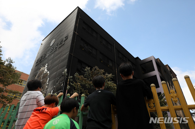 【서울=뉴시스】김선웅 기자 = 27일 서울 은평구 은명초등학교에 학생들이 전날 발생한 화재로 불에 탄 건물을 바라보고 있다. 2019.06.27. mangusta@newsis.com