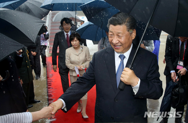 【오사카=AP/뉴시스】 중국의 시진핑 주석이 27일 오사카의 칸사이 국제공항에 도착해 환영객과 악수하고 있다. 시 주석은 2시간 뒤에 도착한 트럼프 대통령과 마찬가지로 부인 동반 없이 혼자 왔다. 2019. 6. 27.
