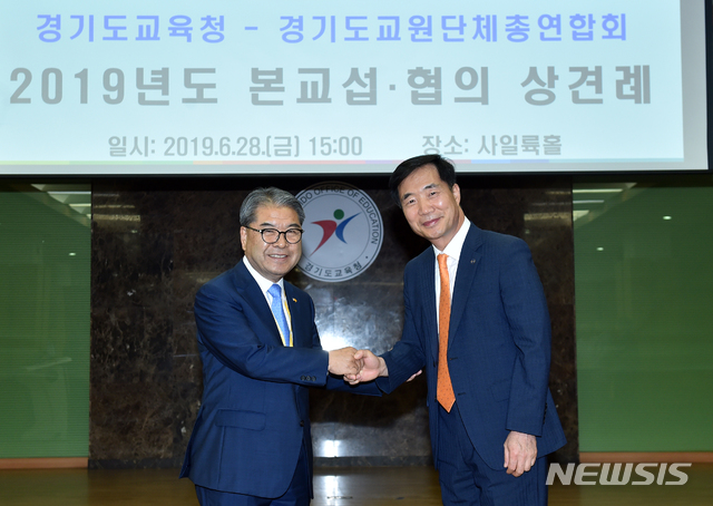 이재정 경기도 교육감과 백정한 경기교총 회장이 2019년 본교섭에 앞서 28일 열린 상견례에서 손을 맞잡고 기념촬영을 하고 있다.