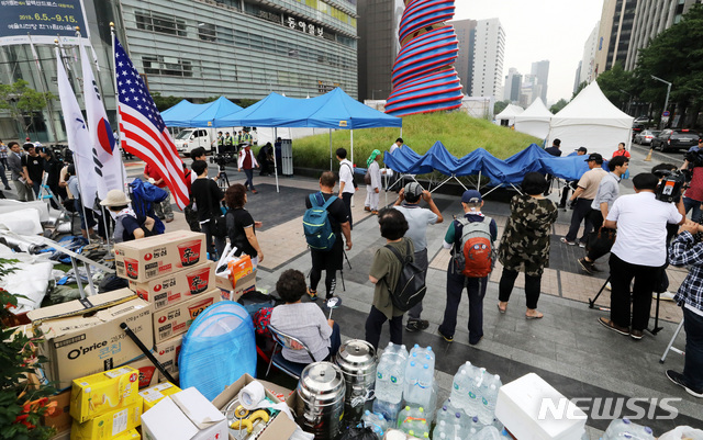 【서울=뉴시스】 고범준 기자 = 28일 우리공화당(구 대한애국당)이 서울 종로구 광화문 광장에 설치된 천막을 철거 한 뒤 파이낸스빌딩 인근 청계광장 앞에서 천막을 옮겨 설치하기 전 짐을 나르고 있다. 2019.06.28. bjko@newsis.com