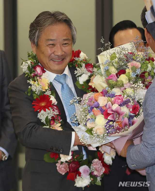 【인천공항=뉴시스】최진석 기자 = 국제올림픽위원회(IOC) 위원으로 선출된 이기흥 대한체육회장이 28일 오후 인천국제공항을 통해 귀국해 관계자들의 축하를 받고 있다.&nbsp; 이 회장은 지난 5월23일 IOC 집행위원회를 통해 국가올림픽위원회(NOC) 자격의 IOC 위원 후보로 추천, 전체 64표 중 과반(32표)를 뛰어 넘는 찬성 57표(반대 5표·기권 2표)를 획득해 IOC 신규 위원이 됐다. 한국인으로는 역대 11번째 IOC 위원이다. 2019.06.28. myjs@newsis.com
