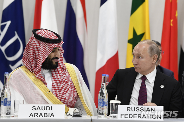 【오사카(일본)=AP/뉴시스】무함마드 빈 살만 사우디아라비아 왕세자(왼쪽)와 블라디미르 푸틴 러시아 대통령이 28일 일본 오사카(大阪)에서 열린 주요 20개국(G20) 정상회담 도중 이야기를 하고 있다. 푸틴 대통령은 29일 사우디와 석유 생산량 감축을 계속할 필요성에 대해 합의했다고 말했다. 2019.6.29