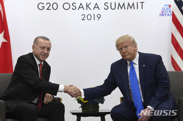 【오사카(일본)=AP/뉴시스】도널드 트럼프 미 대통령(오른쪽)과 레제프 타이이프 에르도안 터키 대통령이 29일 주요 20개국(G20) 정상회담이 열리고 있는 일본 오사카(大阪)에서 정상회담을 시작하면서 악수하고 있다. 2019.6.29