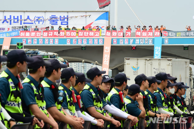 【성남=뉴시스】 김종택 기자 = 30일 오후 경기도 성남시 경부고속도로 서울 톨게이트에서 '한국도로공사 정규직 전환 민주노총 투쟁본부'노조원들이 한국도로공사 용역업체 소속 톨게이트 요금 수납원 직접고용 등을 촉구하며 구조물 위에 올라가 고공시위를 벌이고 있다. 2019.06.30.semail3778@naver.com