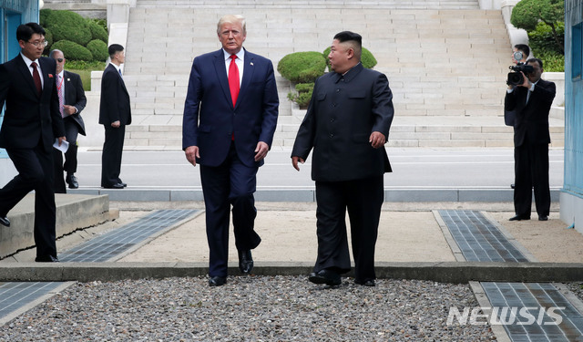 【판문점=뉴시스】박진희 기자 = 도널드 트럼프 미국 대통령이 30일 판문점 공동경비구역(JSA) 군사분계선 북측 지역에서 김정은 북한 국무위원장과 만나 군사분계선을 넘어 오고 있다. 2019.06.30.&nbsp; pak7130@newsis.com