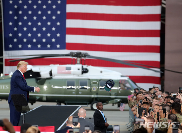 [평택=뉴시스]이영환 기자 = 도널드 트럼프 당시 미국 대통령이 2019년 6월30일 경기 평택시 주한미군 오산 공군기지에서 연설을 마치고 이동하며 모자에 사인을 한 후 장병에게 전하는 모습. 2024.05.01. 20hwan@newsis.com