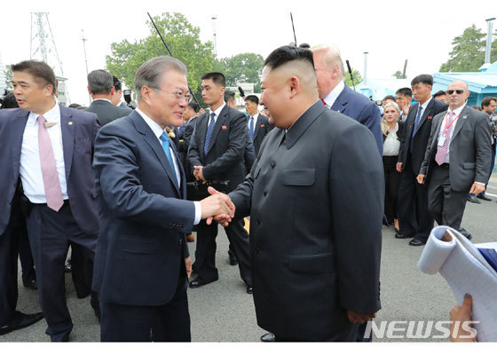 【서울=뉴시스】문재인대통령이 30일 판문점에서 남측으로 내려온 김정은 북한 국무위원장을 반갑게 맞이하고 있다. (출처노동신문 캡처) 2019.07.01