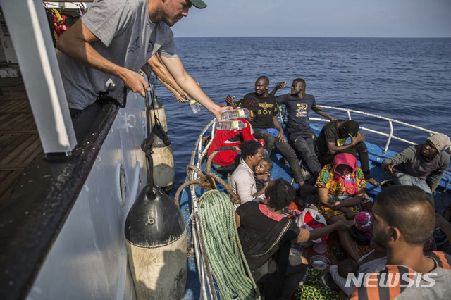 【지중해=AP/뉴시스】 이탈리아 정부의 입항금지로 람페두사 섬 근해에 씨워치 3호가 발이 묶여 있는 가운데 6월 30일(현지시간) 또 다른 구호단체 오픈암스의 구조선이 지중해 상에서 표류중인 난민선을 발견하고 식수와 구호식품을 전하고있다. 2019.-07.01