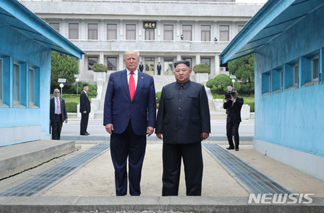 [서울=뉴시스] 도널드 트럼프 미국 대통령이 1기 행정부 시절인 2019년 6월 30일 김정은 북한 국무위원장과 비무장지대 판문점에서 만나 군사분계선을 넘은 뒤 포즈를 취하고 있다. 2025.10.27. (출처=노동신문) 