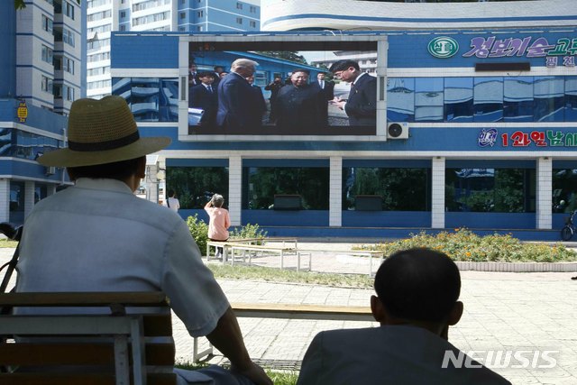 【평양=AP/뉴시스】1일 평양 시내 미래과학자거리에서 시민들이 6월 30일 판문점에서 김정은 북한 국무위원장과 도널드 트럼프 미국 대통령이 만나는 모습을 대형 화면 속 뉴스를 통해 접하고 있다. 2019.07.01.