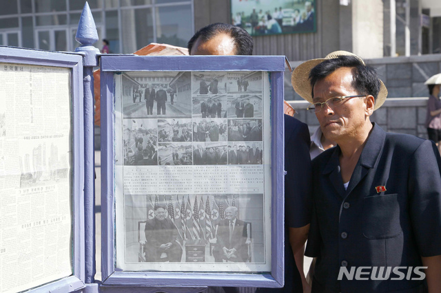 【평양=AP/뉴시스】1일 평양 시내 미래과학자거리 게시판에서 시민들이 6월 30일 판문점에서 김정은 북한 국무위원장과 도널드 트럼프 미국 대통령의 회동 기사를 읽고 있다. 2019.07.01.