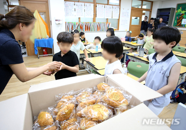 【청주=뉴시스】 인진연 기자 = 충북 학교비정규직연대회의(학비연대)가 총파업에 들어간 3일, 충북 청주 한 초등학교에서 아이들에게 빵과 우유를 나눠주고 있다. 2019.07.03.inphoto@newsis.com