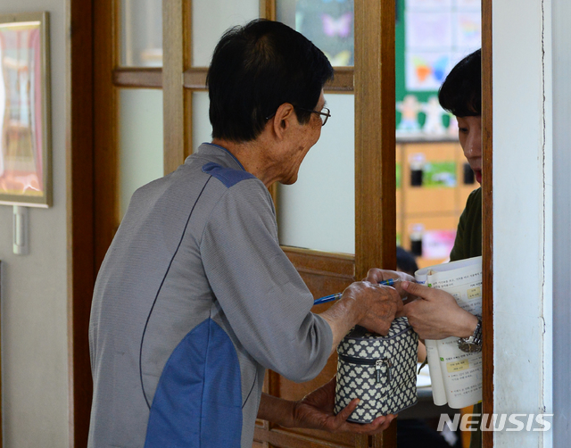 【청주=뉴시스】 인진연 기자 = 충북 학교비정규직연대회의(학비연대)가 총파업에 들어간 3일, 충북 청주 한 초등학교를 찾은 할아버지가 손자의 도시락을 전달하고 있다. 2019.07.03.inphoto@newsis.com