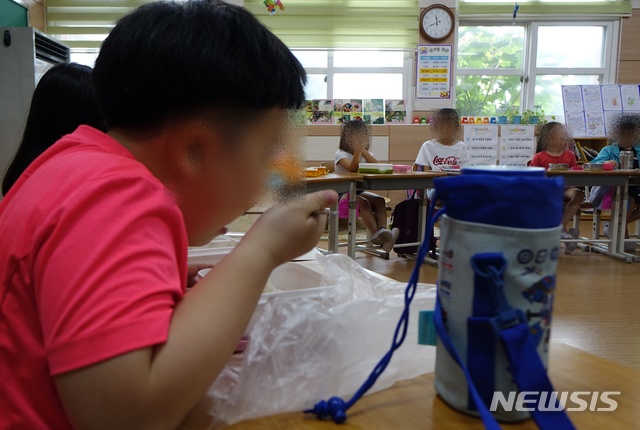 【제주=뉴시스】배상철 기자 = 3일 제주학교비정규직연대회의의 총파업 돌입으로 급식이 중단되자 도내 한 초등학교 학생들이 집에서 싸온 도시락으로 점심을 먹고 있다. 2019.07.03. bsc@newsis.com