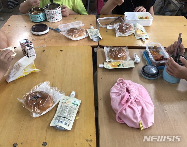 【대구=뉴시스】이은혜 기자 = 교육공무직 노조(전국학교비정규직연대회의)가 공공부문 총파업에 돌입한 3일 오후 대구시 수성구의 한 초등학교에서 학생들이 급식 대신 빵과 도시락으로 점심을 해결하고 있다. 2019.07.03. ehl@newsis.com