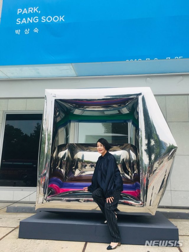 【서울=뉴시스】박현주 미술전문기자= 3일 오전 박상숙 작가가 서울 삼청로 현대화랑앞에 설치한 거대 스테인리스 조각품에 앉아 설명하고 있다.