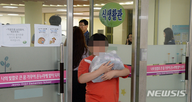 【전주=뉴시스】 김얼 기자= 전국 학교 비정규직 노동자들이 파업을 실시한 3일 전북 전주시 전주온빛초등학교에서 학생들이 학교에서 점심 대신 준비한 빵과 음료를 나르고 있다. 2019.07.03.pmkeul@newsis.com