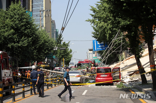 [서울=뉴시스]김선웅 기자 = 지난해 7월4일 오후 서울 서초구 잠원동의 한 철거 중인 건물 외벽이 붕괴하는 사고가 발생했다. 인근 차량이 사고 영향으로 넘어진 전신주에 깔려 있다. 2019.07.04. mangusta@newsis.com