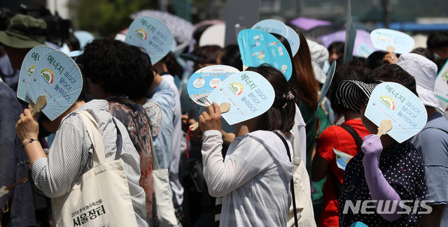 【서울=뉴시스】김선웅 기자 = 서울 낮 최고 기온이 34도를 기록하며 폭염경보가 발효된 5일 서울 종로구 세종로사거리에서 열린 에너지절약 캠페인 참가자들이 부채로 햇볕을 가리고 있다. 2019.07.05. mangusta@newsis.com