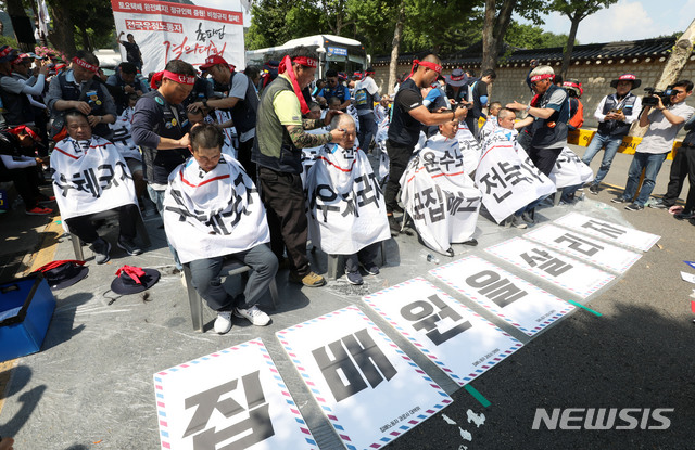 【서울=뉴시스】홍효식 기자 = 전국집배노동조합원들이 6일 오후 서울 종로구 청와대 사랑채 인근 도로에서 열린 노동조건 개선 촉구 총파업 결의대회에서 삭발식을 하고 있다. 2019.07.06. yesphoto@newsis.com