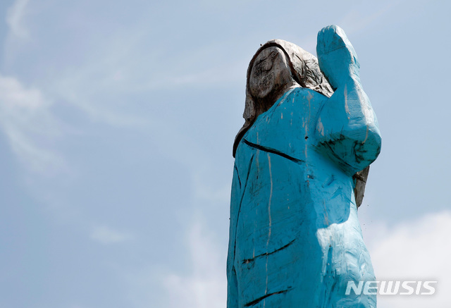 【세브니카(슬로베니아)=AP/뉴시스】5일(현지시간) 도널드 트럼프 미국 대통령의 부인 멜라니아 여사의 고향인 슬로베니아 세브니카 교외에 멜라니아 트럼프 동상이 세워져 있다.실물 크기의 이 동상을 제작한 미국의 예술가 브래드 다우니는 트럼프 대통령 취임식 때의 멜라니아 여사 모습을 나무로 형상화했다고 밝혔으나 이에 대해 현지인들은 '허수아비' 같다며 반응이 엇갈리고 있다. 2019.07.07. 