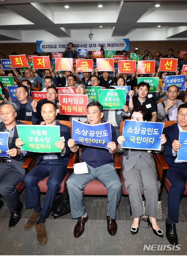 【서울=뉴시스】이영환 기자 = 10일 오후 서울 동작구 소상공인연합회에서 열린 '소상공인연합회 2019년도 제1차 임시총회 및 업종·지역 특별 연석회의'에서 최승재(앞줄 가운데) 소상공인연합회 회장 등 참석자들이 최저임금 차등화, 주휴수당 문제 즉각 해결을 촉구하며 구호를 외치고 있다. 2019.07.10. 20hwan@newsis.com