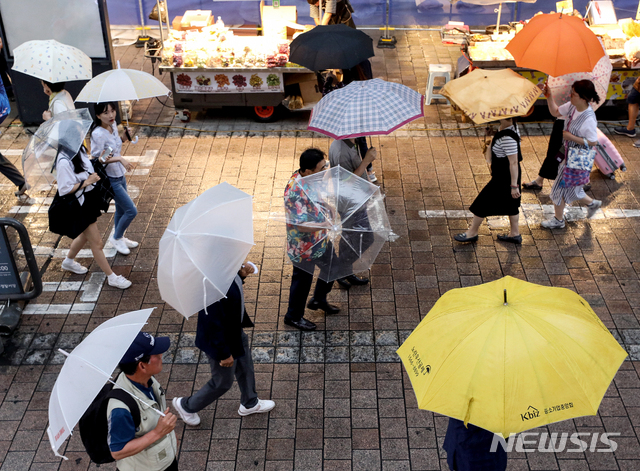 【서울=뉴시스】김병문 기자 = 전국에 장맛비가 내린 지난 10일 오후 서울 중구 명동에서 시민들이 우산을 쓰고 있다. 2019.07.10. dadazon@newsis.com