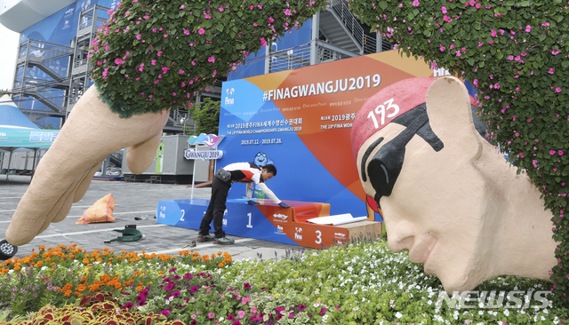 【광주=뉴시스】최진석 기자 = 2019 광주세계수영선수권대회 개막을 하루 앞둔 11일 2019광주세계수영선수권대회 주경기장인 광주 광산구 남부대학교 시립국제수영장 관람객 출입구 인근에서 관계자가 기념촬영 시상대 설치를 하고 있다. 2019.07.11.&nbsp; myjs@newsis.com
