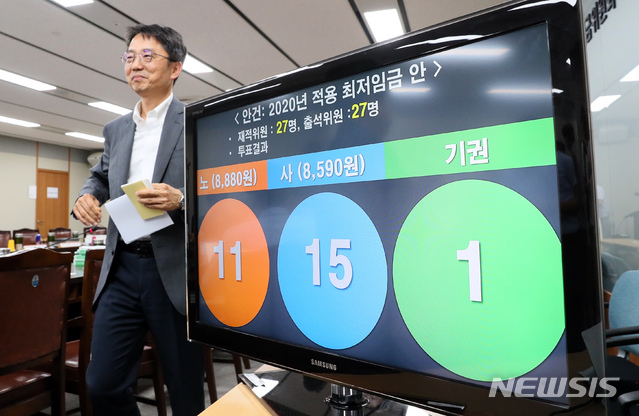 【세종=뉴시스】강종민 기자 = 12일 새벽 정부세종청사에서 열린 최저임금위원회 전원회의에서 2020년 최저임금이 2.9% 인상된 8590원으로 결정됐다.&nbsp; 박준식 최임위원장이 결정된 최저임금안 앞을 미소를 지으며 지나고 있다. 2019.07.12.&nbsp; ppkjm@newsis.com