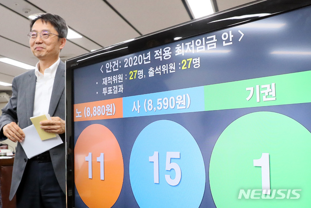 【세종=뉴시스】강종민 기자 = 12일 새벽 정부세종청사에서 열린 최저임금위원회 전원회의에서 2020년 최저임금이 2.87% 인상된 8590원으로 결정됐다. 박준식 최임위원장이 결정된 최저임금안 앞을 미소를 지으며 지나고 있다. 2019.07.12. ppkjm@newsis.com
