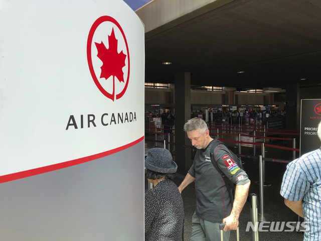 【호놀룰루= AP/뉴시스】 11일 난기류로 35명이 부상을 입은 에어 캐나다의 호주행 승객들이 호놀룰루의 대니얼 K. 이노우에국제공항에서 다른 항공편으로 갈아타기 위해 항공사 카운터 앞에 줄을 서고 있다.